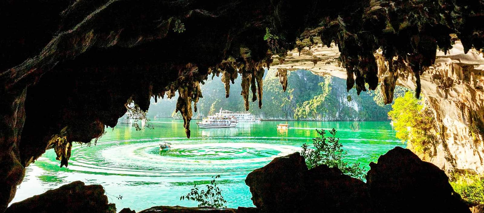 Luon Cave in Halong Bay with emerald water and limestone cliffs in Vietnam