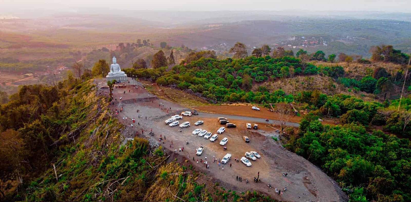 Panoramic view of Ratanakiri with lush green hills and a white pagoda.