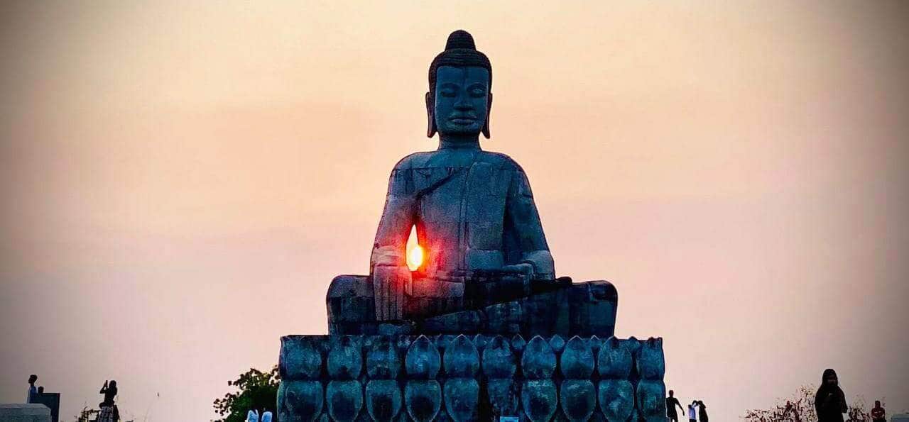 Buddha statue at sunset, symbolizing peace and spirituality, perfect for travel and cultural explora.