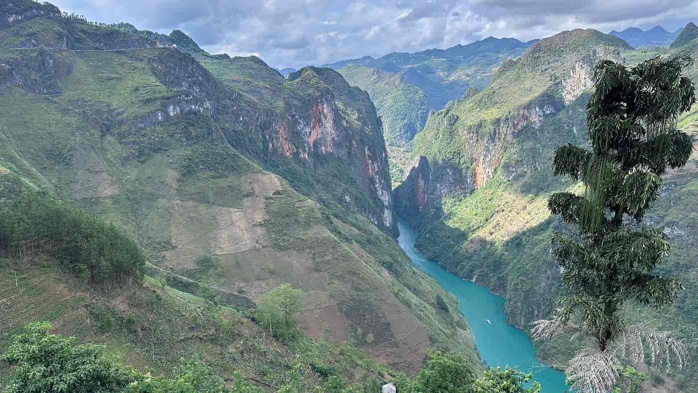 Breathtaking mountain scenery featuring a winding river through a lush canyon with green hills and d.