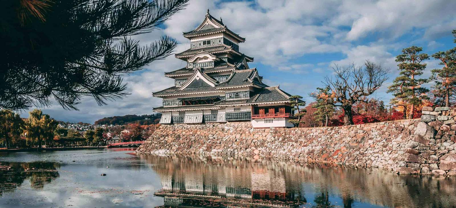Japanese castle with traditional design and scenic landscape.