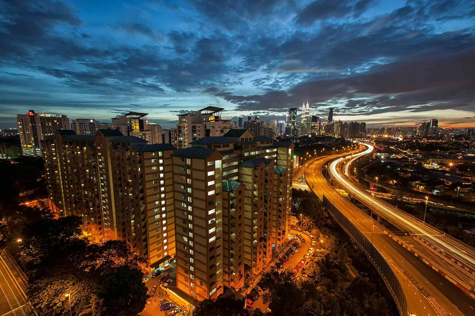 City skyline with high-rise buildings and vibrant evening lights in a bustling urban area.