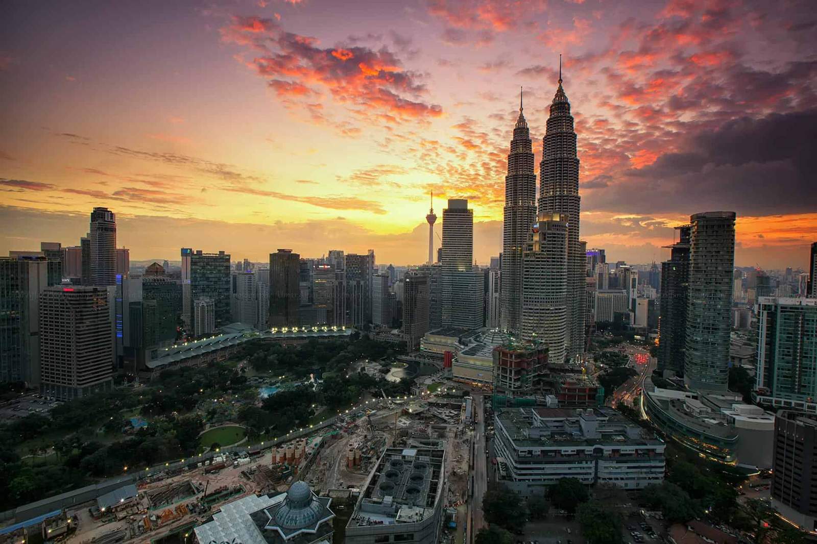Kuala Lumpur cityscape featuring the iconic Petronas Towers during a vibrant sunset. Perfect for tra.
