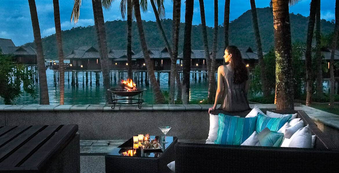 Overwater bungalow with tropical setting and sunset view.