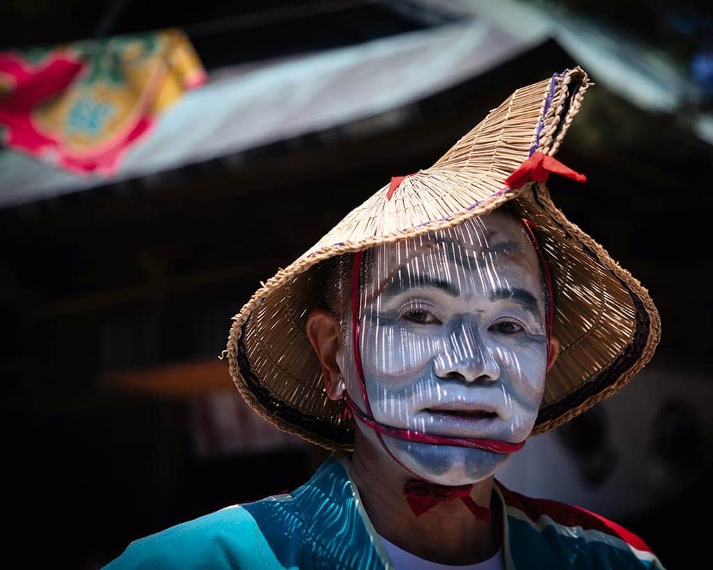 Traditional Asian face painting and straw hat.