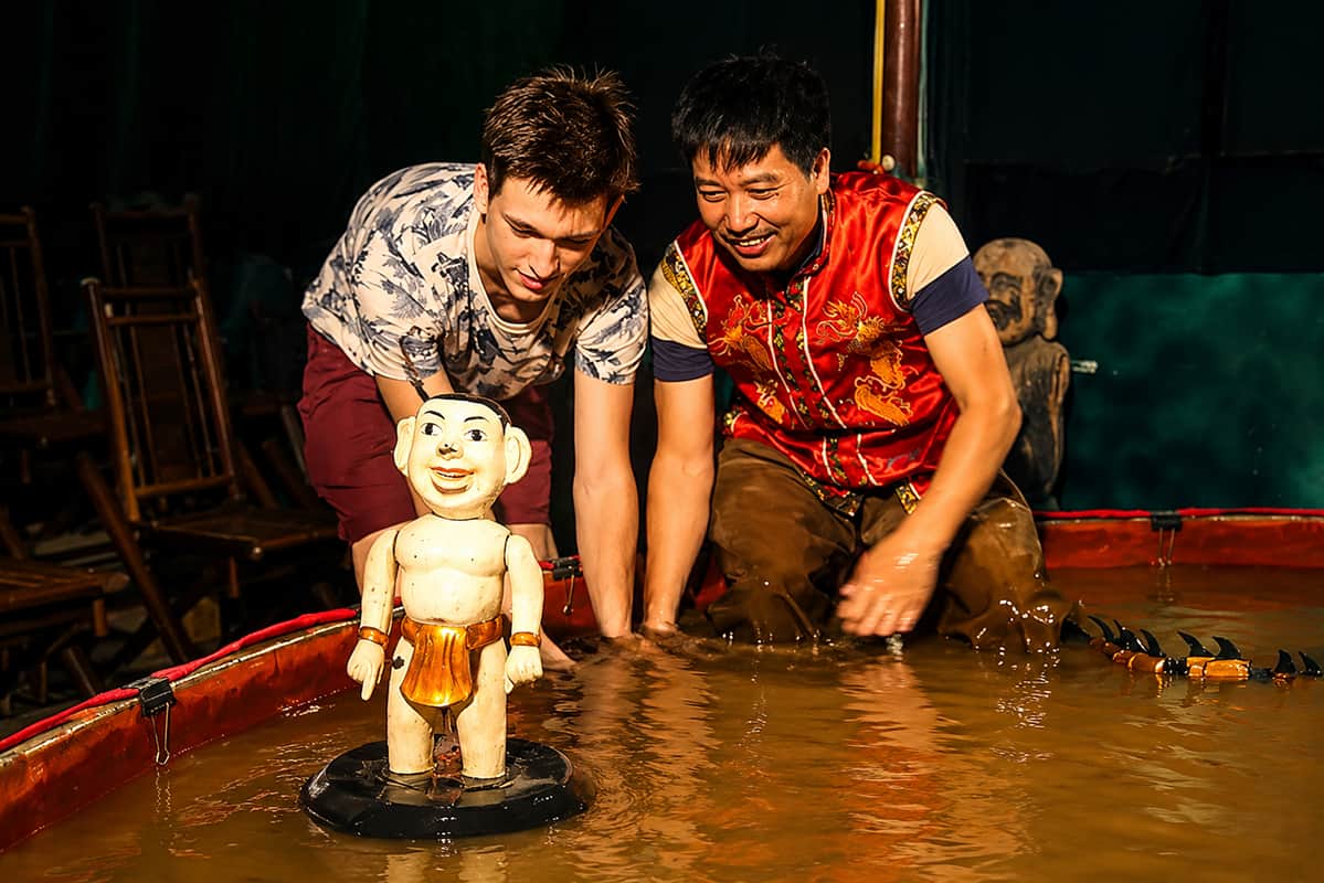 Traditional Vietnamese water puppet performance with puppeteers controlling puppets on water